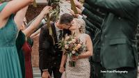 Bride and Groom Kissing in wedding party tunnel in front of Gorecki Alumni Center