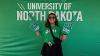 A young alum poses with a foam finger at the tailgating tent to celebrate milestone grads 