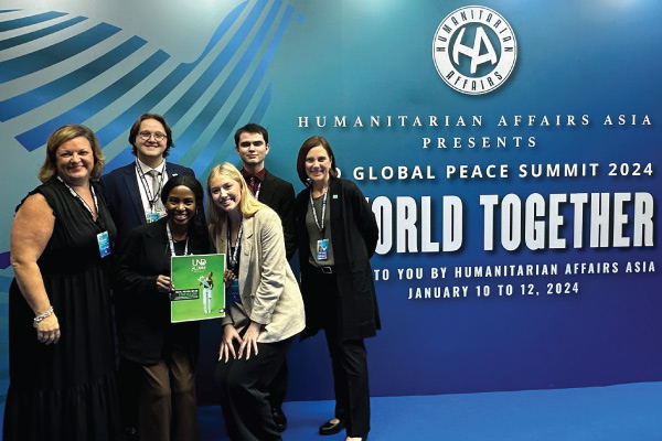 UND students holding Alumni Magazine at Peace Summit