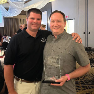 George and Jason holding an award