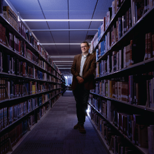 brian garrison standing among stacks of books