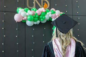 UND Student wearing cap and gown