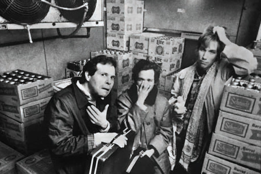 three people make silly faces in a restaurant cooler