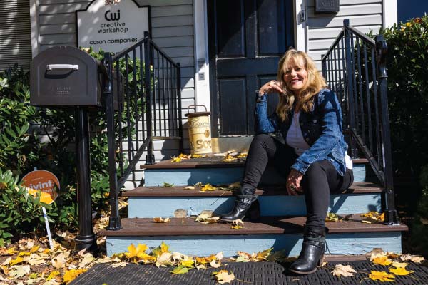Carol Chase sitting on steps in front of a home