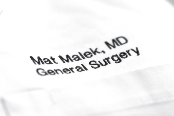 A white physician's coat belonging to Mat Malek, MD