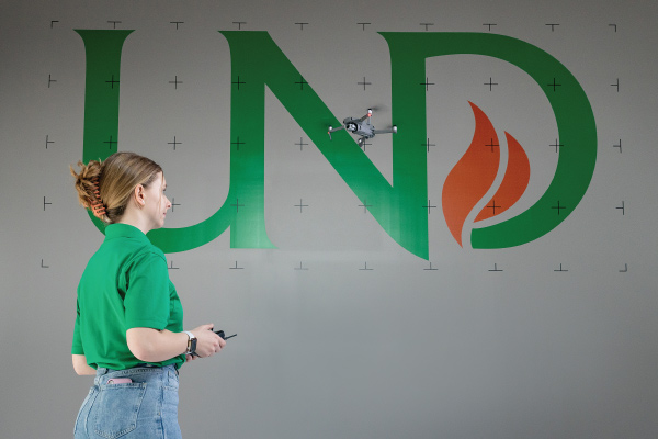 Student with drone and UND sign