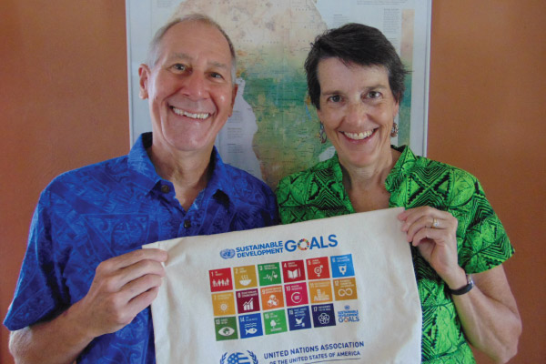 Jill and Dave Engelstad holding a sustainable development goals flag