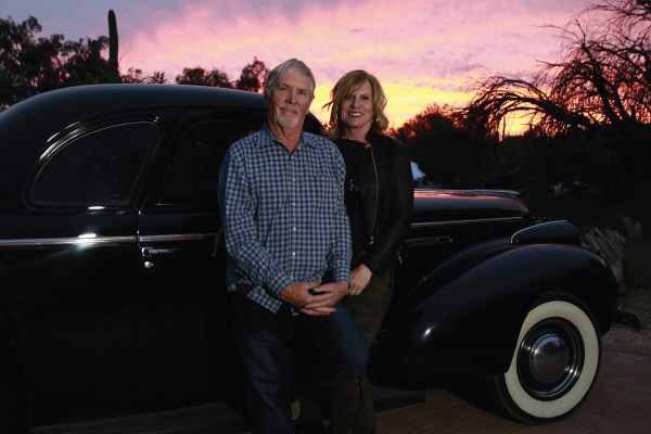 couple stands by classic car