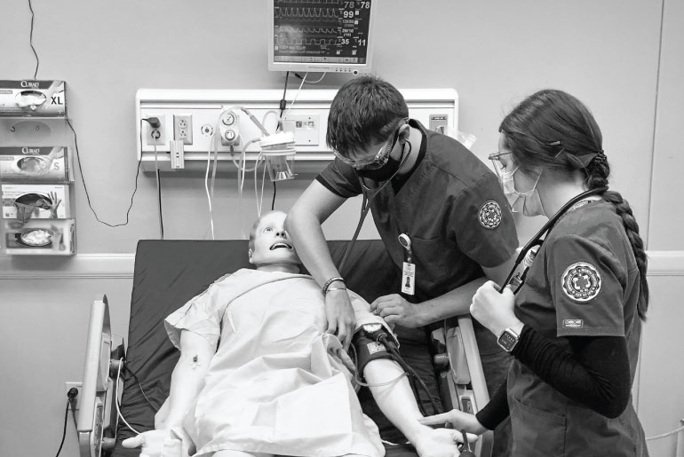 Nursing students practicing their skills on a mannequin