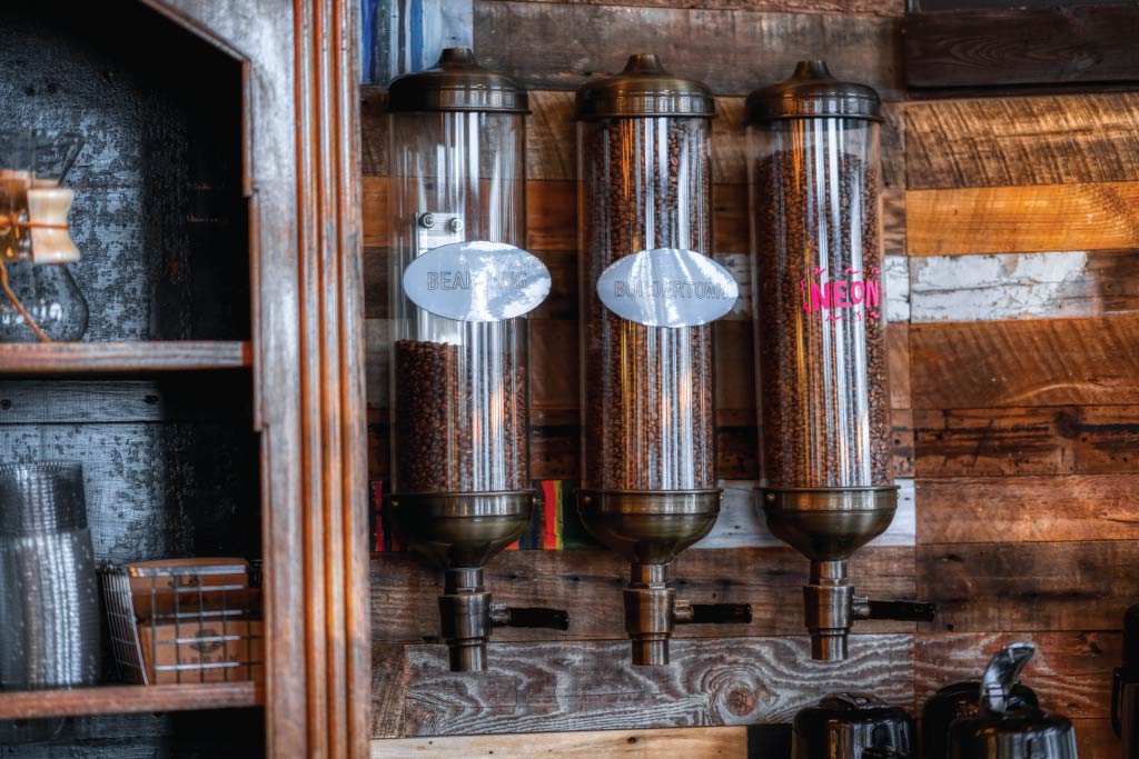 Three containers of coffee beans hanging on a wall