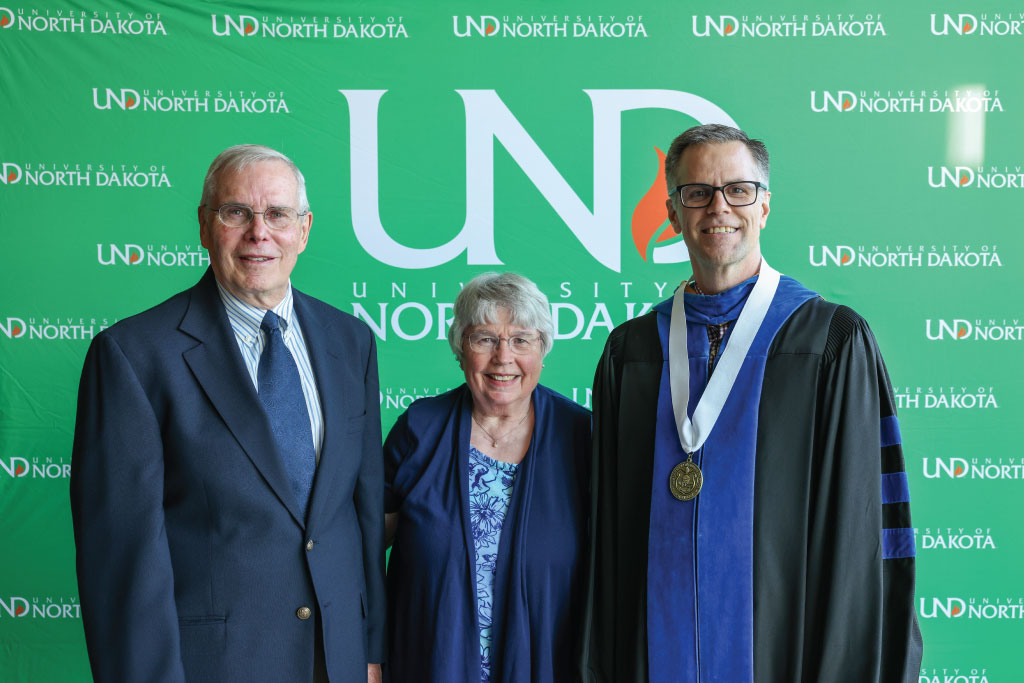 three people in front of green background