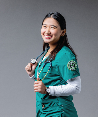 person wearing green scrubs and holding stethoscope