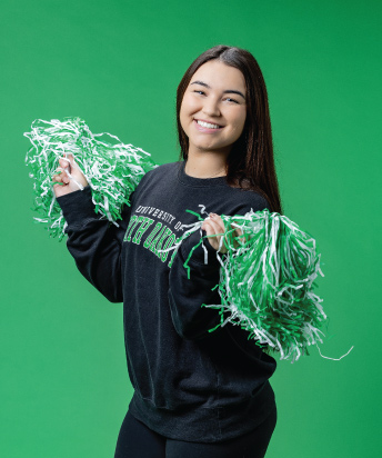person holding pom poms on green background