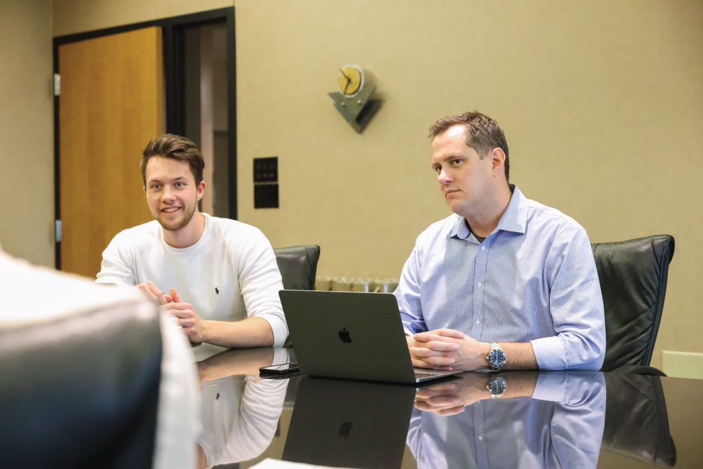Tyler Sletten and a UND student working in a boardroom